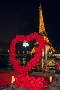 Red flowers and white candles on ground