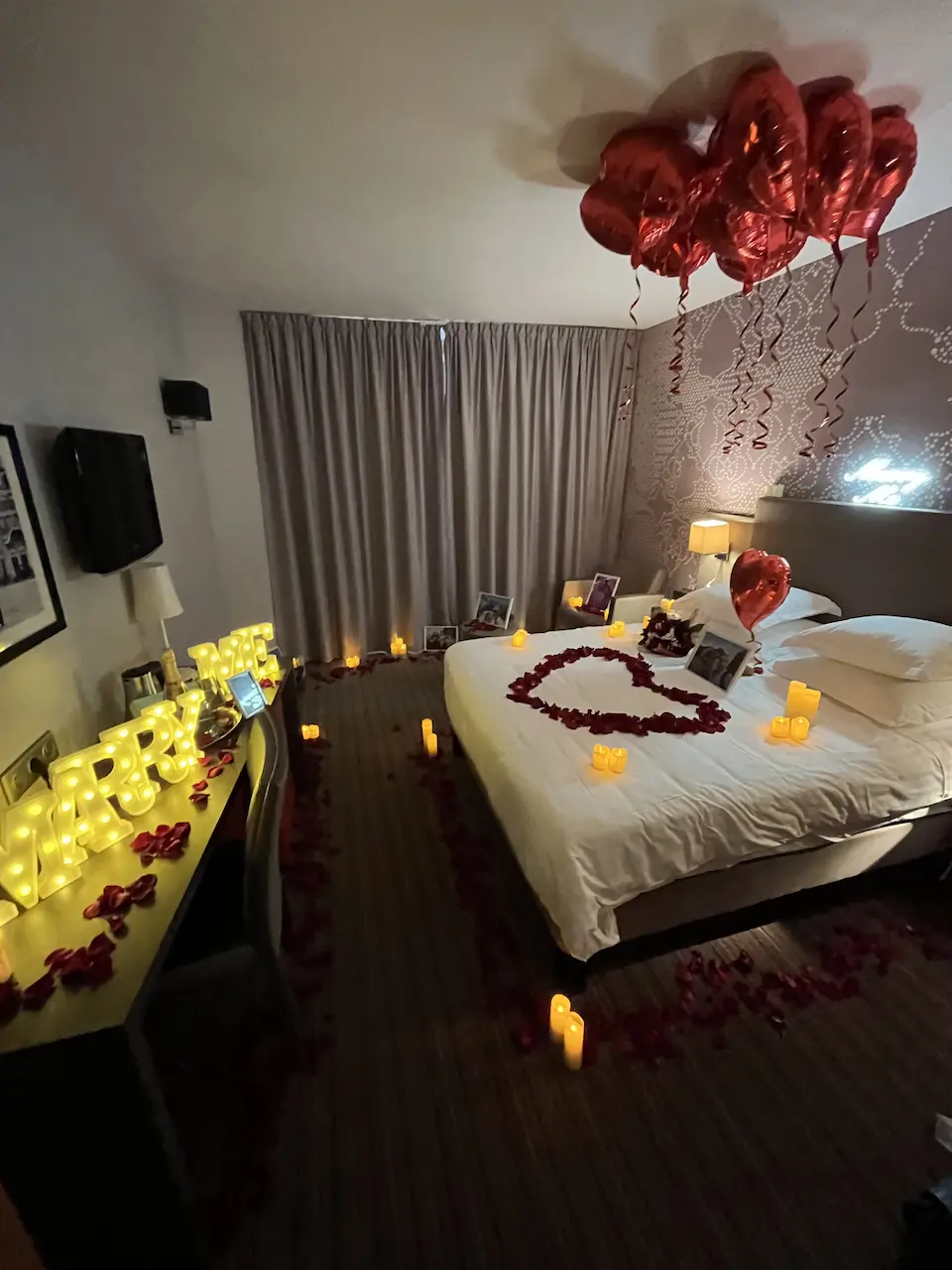 Bed with pillows table and balloons