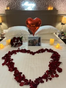 Bed with candles bouquet and balloons