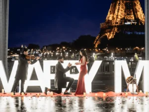 Man playing violin with kneeling man and woman