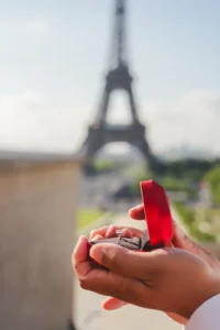 Hand holding ring box with Eiffel Tower