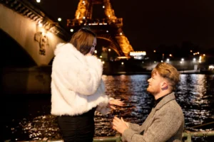 Couple at railing with water bridge lights